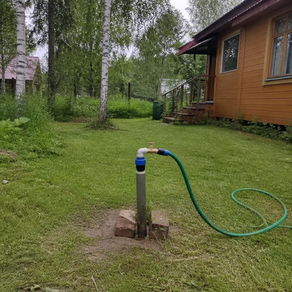 Летний оголовок скважины на участке у дачного дома